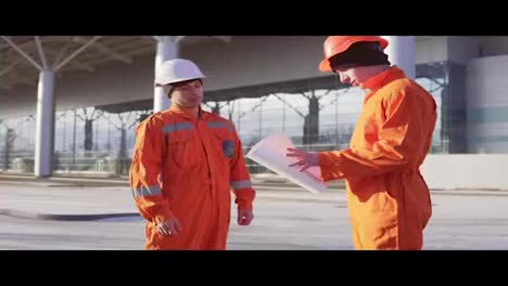 Manager-of-the-project-examining-the-building-object-with-construction-worker-in-orange-uniform-and-helmet.-They-meeting-each-other-at-the-bulding-object-and-shaking-hands.