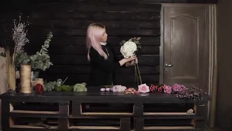 Impressive-front-florist-shooting-at-work.-A-nice-girl-collects-flowers-in-a-composition.-Indoors