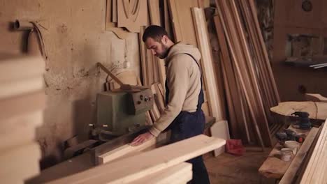 Side-view-of-a-craftman-working-on-a-electric-saw-with-wood.-Pushes-the-wooden-block-by-hands