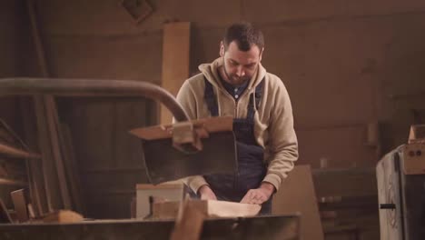 Front,-close-up-footage-of-sawing-wood-on-a-circular-machine.-Carpenter-in-overalls
