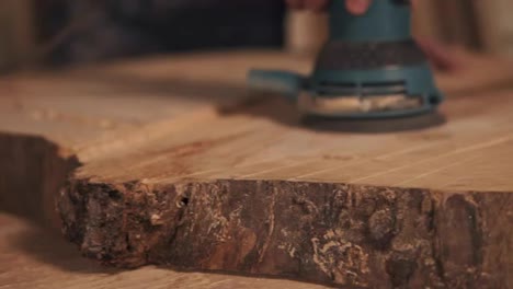 Extremely-close-shooting-of-manual-grinding-process-in-carpenter's-hand.-Wood-dust
