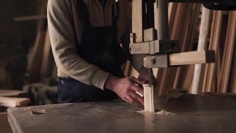 Slow-motion-footage-of-carpenter-working-with-a-wood-block-in-workshop.-Electric-saw.-Wooden-furniture-behind