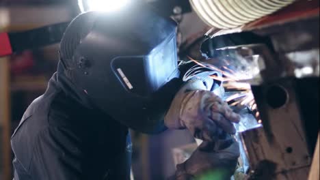Male-worker-at-a-welding-factory-in-a-protective-eyewear.-Welding-on-an-industrial-plant.-Slow-motion.
