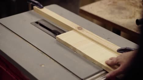 High-angle-footage-of-cutting-wooden-board-on-saw-machine.-Action.-Industrial-machine-with-circular-saw-cuts-wooden-board.-Woodworking-shop,-working-at-machine-on-cutting-of-wood