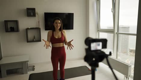 A-young-woman-fitness-instructor-records-a-tutorial-on-home-workouts-on-camera