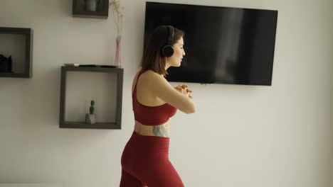 Woman-putting-on-music-in-headphones-and-starting-stretching-legs