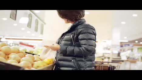 Junge-Frau-Kauft-Im-Lebensmittelgeschäft-Ein-Und-Wählt-Orangen-Aus