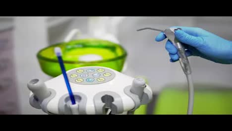 Dentists-hands-take-the-medical-tools-and-pouring-water-out-at-dental-clinic.-Close-up.-Concept-of-healthy-life