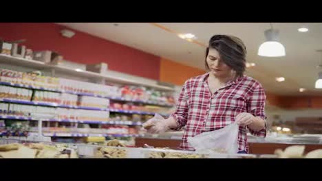 Young-woman-choosing-biscuits-and-shortcakes-at-the-supermarket.-4k