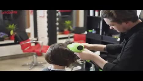 Professional-hairdresser-is-drying-hair-of-young-attractive-woman-in-beauty-salon.-Shot-in-4k