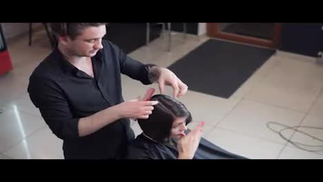 Professional-hairdresser,-stylist-makes-professional-hairstyle-of-young-woman-in-beauty-studio.-Beauty-and-haircare-concept
