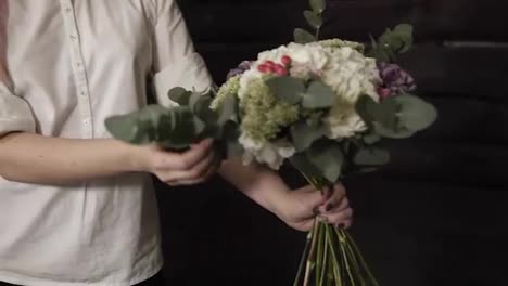 A-beautiful-bouquet-design-in-the-hands-of-a-charming-girl-with-pink-hair-and-a-white-shirt.-Slow-motion