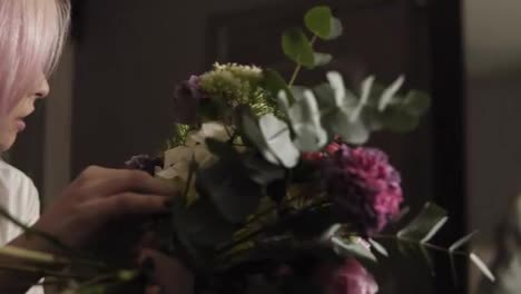 Eine-Schöne-Floristin-Korrigiert-Und-Füllt-Einen-Blumenstrauß-Mit-Blumen,-Während-Sie-Ihn-Im-Spiegelbild-Betrachtet