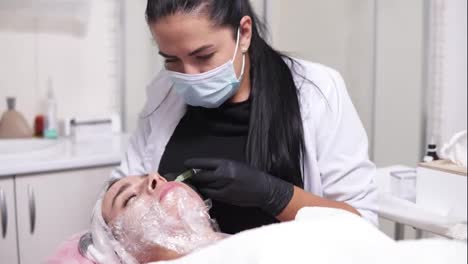 Shot-in-4k:-professional-comsetologist-in-mask-making-multiple-injections-in-woman's-cheek-during-mesotherapy.-Biorevitalization-and-face-lifting,-non-surgical-medicine-treatment