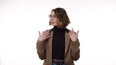 Portrait-of-young-woman-in-jacket-and-jeans-shows-how-hot-it-is-with-hand-gestures-on-an-isolated-white-background-looking-to-the-sides.-Confused-and-irritated.-Copy-space.-The-emotions-of-people