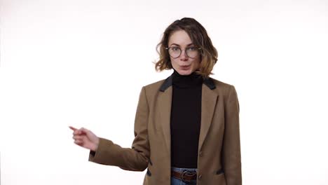 Beautiful-young-brunette-woman-in-glasses-with-finger-on-lips-showing-silent-or-hush-gesture-and-wink-playfully-isolated-on-white-background.-Girl-wearing-black-blazer-and-strict-brown-jacket