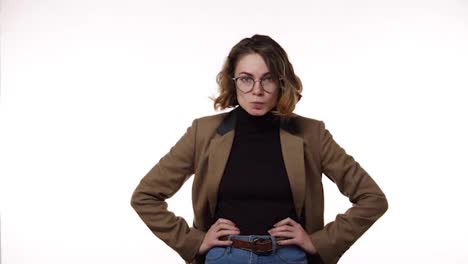 Angry,-irritated-emotions.-Hush-and-keep-silence.-Caucasian-brunette-woman-in-glasses-with-finger-on-lips-showing-silent-or-hush-gesture-isolated-on-white-background.-Girl-wearing-black-blazer-and-strict-brown-jacket