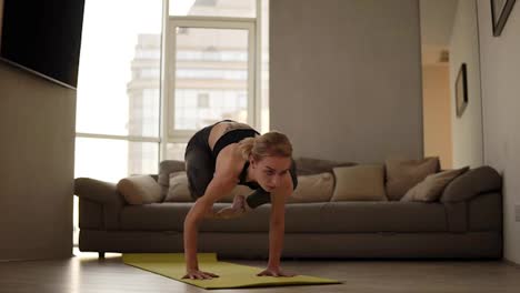 Healthy-woman-exercising-at-home-practicing-yoga-poses-in-living-room-enjoying-morning-fitness-workout.-Blonde-girl-doing-cobra-pose-in-slow-motion