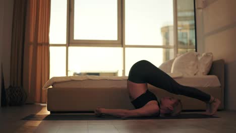 Yogi-girl-doing-sarvangasana-plow-pose-from-for-relaxation-heart-muscles-healing-for-the-spine-strengthensrthen-back-to-a-lotus-pose-with-namaste.-Training,-yoga-at-home-in-the-living-room