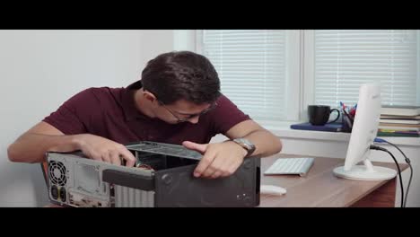 Young-professional-worker-trying-to-repair-a-computer-in-the-office-using-a-screwdriver-and-upgrading-computer-hardware.-Shot-in-4k