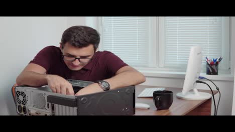 Young-professional-worker-repair-a-broken-computer-in-the-office-using-a-screwdriver-and-upgrading-computer-hardware.-Support-team.-Computer-maintenance.-Shot-in-4k