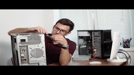Concentrated-computer-service-worker-in-glasses-fixing-a-broken-computer-in-the-office-and-upgrading-computer-hardware.-Support-team.-Computer-maintenance.-Shot-in-4k