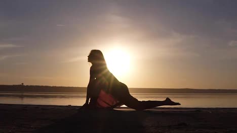 Silhouette-Einer-Schönen-Yoga-Frau-Am-Morgenhimmel-An-Einem-Meeresstrand.-Eine-Frau,-Die-Yoga-Virabhadrasana-II-Krieger-II-Pose-Praktiziert.-Meditationsposition-Vor-Dem-Meer-Bei-Sonnenaufgang