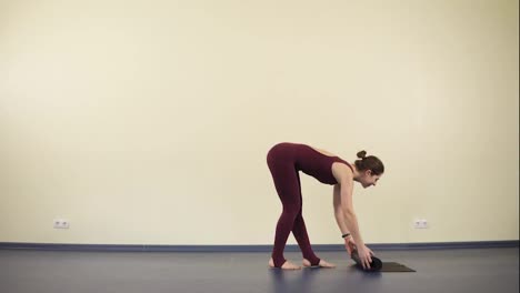 Junge-Attraktive-Frau-Mit-Flexiblem-Und-Fittem-Körper-Beginnt-Mit-Der-Yoga-Praxis-Auf-Einer-Schwarzen-Matte