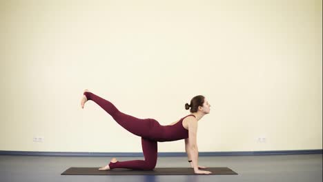 Young-attractive-woman-with-flexible-and-fit-body-does-yoga-exercises-on-black-mat,-indoor-footage.-Healthy-lifestyle,-beautiful-body.