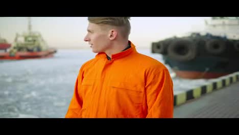 Hafenarbeiter-In-Orangefarbener-Uniform-Mit-Blick-Auf-Das-Meer-Und-Genießen-Die-Landschaft-Des-Hafens-Im-Winter.-Vereistes-Meer