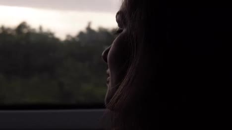 Close-up-of-woman's-face-looking-to-window-in-moving-train.-Darkened.-Evening-dusk.-Side-view