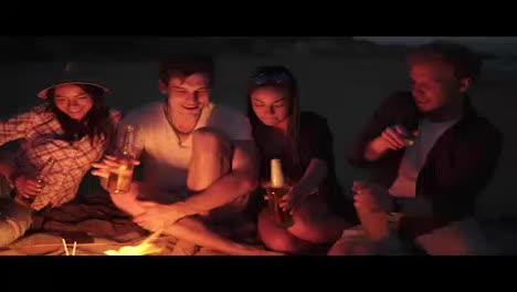 Gruppe-Junger-Leute,-Die-An-Einem-Sommerabend-Mit-Bierflaschen-Anstoßen-Und-Eine-Strandparty-Veranstalten-Und-Mit-Bier-In-4K-Jubeln