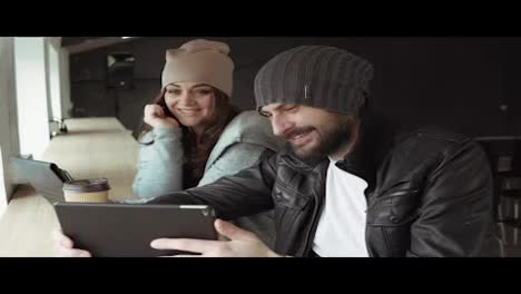 Work-meeting-in-creative-office.-Young-man-and-woman-using-a-tablet-to-watch-video.-Shot-in-4k