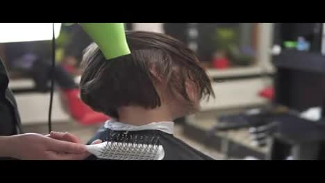 Hairdresser-with-hair-dryer-at-work.-Beauty-saloon.-Shot-in-slowmotion