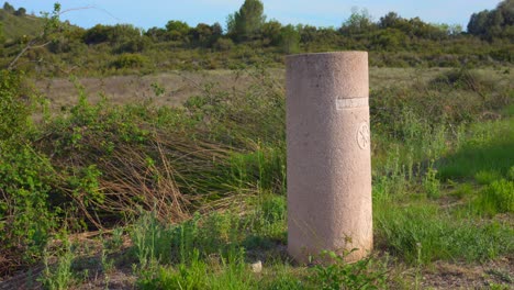 Via-Augusta-Concrete-Marker-On-The-Grassy-Field-In-Castellon-Province,-Spain