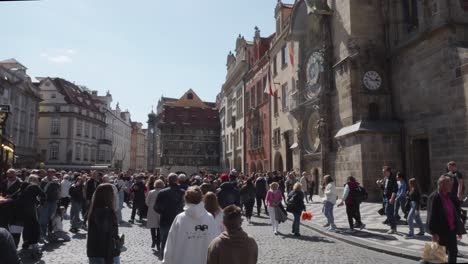 people-walking-and-exploring-the-historic-Old-Town-Square-and-famous-astronomical-clock-in-Prague,-Czech-Republic