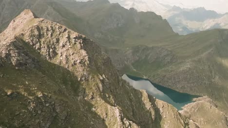 FPV-drone-rapidly-descends-towards-Kleiner-Seefeldsee,-a-stunning-turquoise-mountain-lake,-while-tracing-rugged-mountains