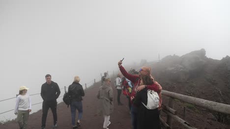 Couple-Taking-Selfie-At-Rim-Of-Mount-Vesuvius-Surrounded-By-Fog-And-Mist