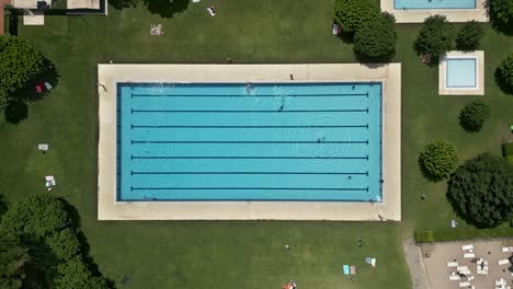 An-outdoor-public-swimming-pool-has-people-enjoying-it’s-facilities