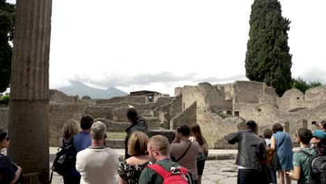 Tour-Guide-Showing-Pompeii-Ruins-Beside-Via-del-Tempio-d’Iside