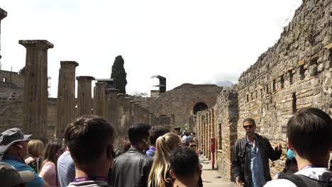 Grupo-De-Turistas-Escuchando-Al-Guía-Turístico-Contando-La-Historia-De-Quadriporticus-De-Los-Teatros-En-Pompeya