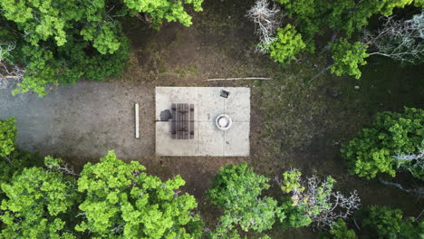 Campground-setup-amidst-lush-green-trees-in-lush-forest,drone-shot