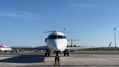 Vista-De-Cerca-De-Un-Jet-De-Tamaño-Mediano,-Bombardier-Crk,-Paring-En-El-Stand-Antes-De-Desembarcar-A-Los-Pasajeros