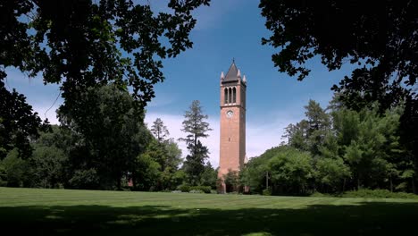 Iowa-State-University-Campanile-in-Ames,-Iowa-with-view-through-trees-and-lawn-stable-video