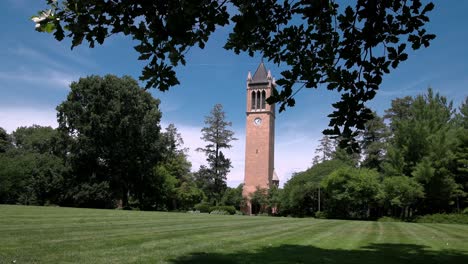 Iowa-State-University-Campanile-in-Ames,-Iowa-with-view-through-trees-and-lawn-stable-video-wide