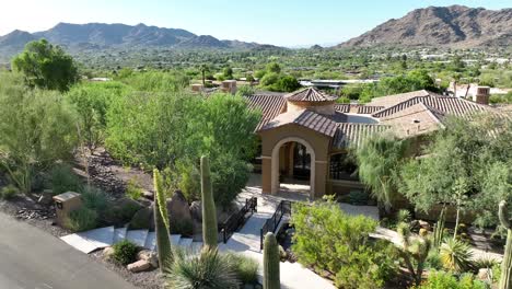 Saguaro-cacti-in-front-of-luxurious-home-in-beautiful-mountain-in-southwest-USA-desert