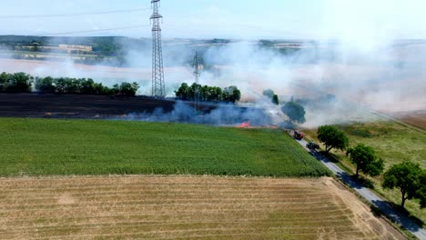 Grain-Field-Burning-With-Red-Fire-And-Smoke---aerial-drone-shot