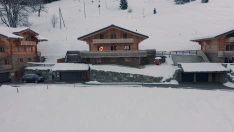 Drone-slowly-flying-towards-a-luxurious-chalet-in-winter