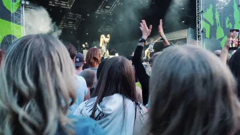 Riga,-Latvia---14-July-2023:-Unrecognizable-Fans-Dancing-Mosh-pit-and-Raising-Their-Hands-at-a-Concert-or-Festival-Party-Silhouettes-of-Crowd-Audience-Enjoying-Concert-in-Front-of-Bright-Stage-Lights
