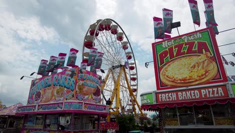 Carnival-state-fair-deep-fried-food-stands-ferris-wheel-big-clouds-summer